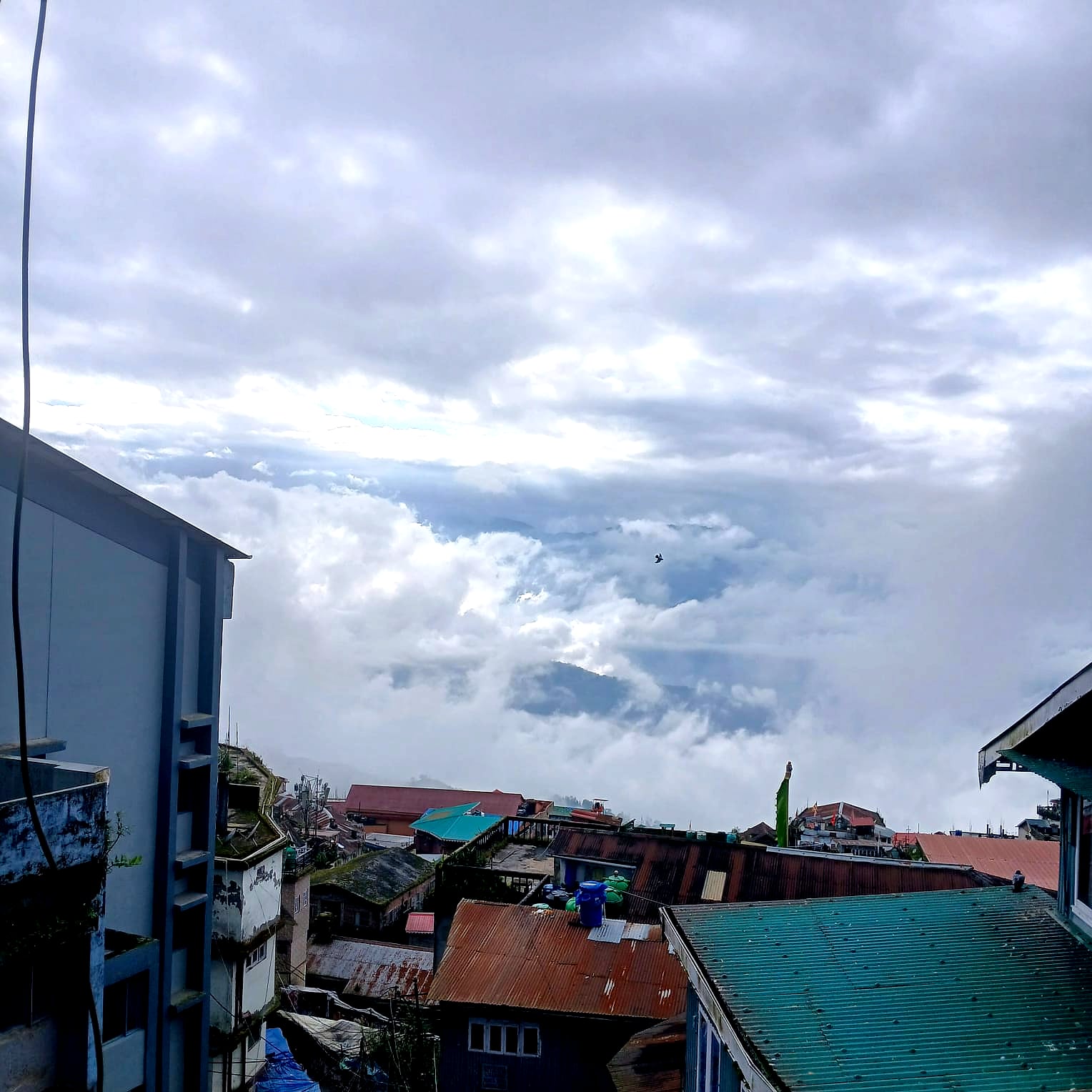 Cloud over the rooftops of Darjeeling, from a room window