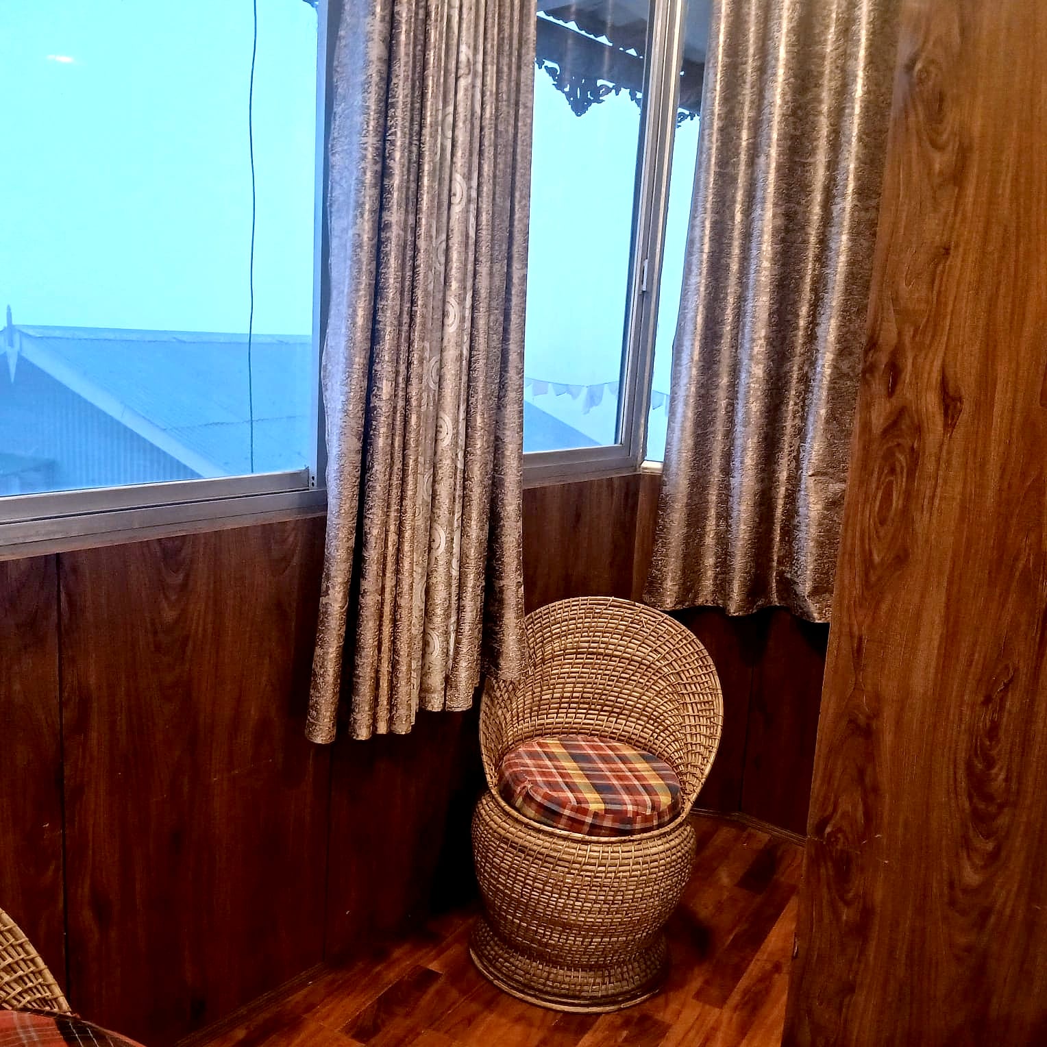 Cane chairs by a room window at Hotel Charlie