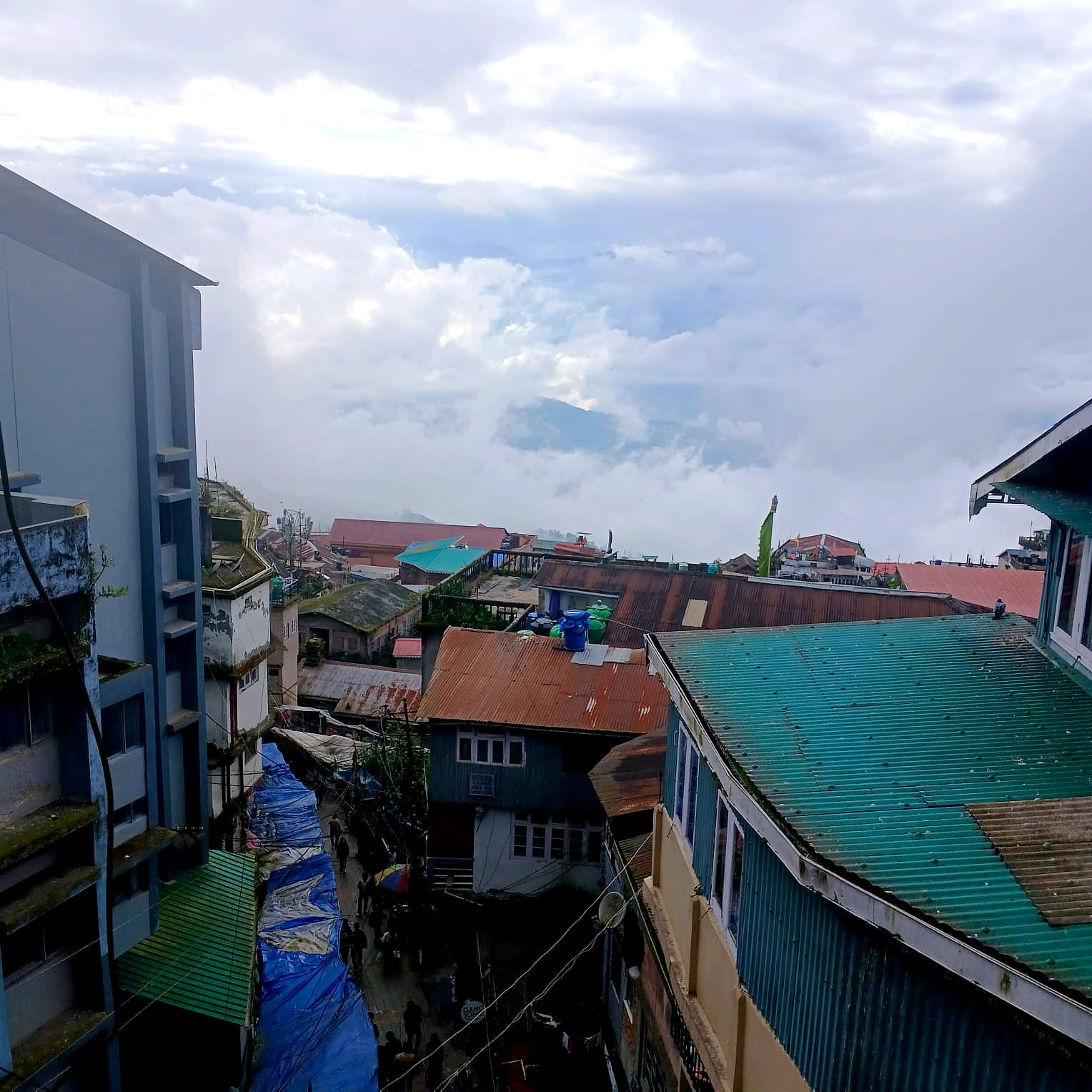 Monsoon cloud rolling over the rooftops of Darjeeling, seen from a room window